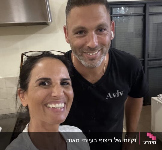 שני אנשים מחייכים במטבח, אין אלמנטים של ניקיון נראים